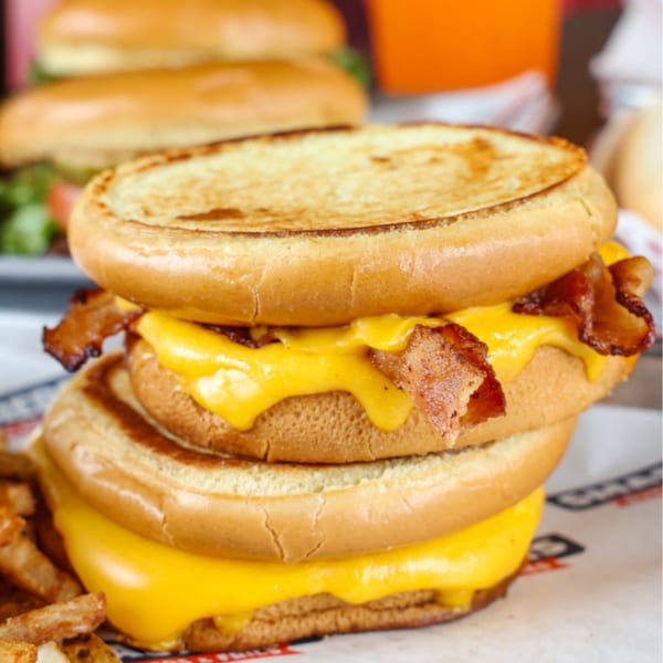 A double Smashers burger with melted cheese and crispy bacon, served with fries.