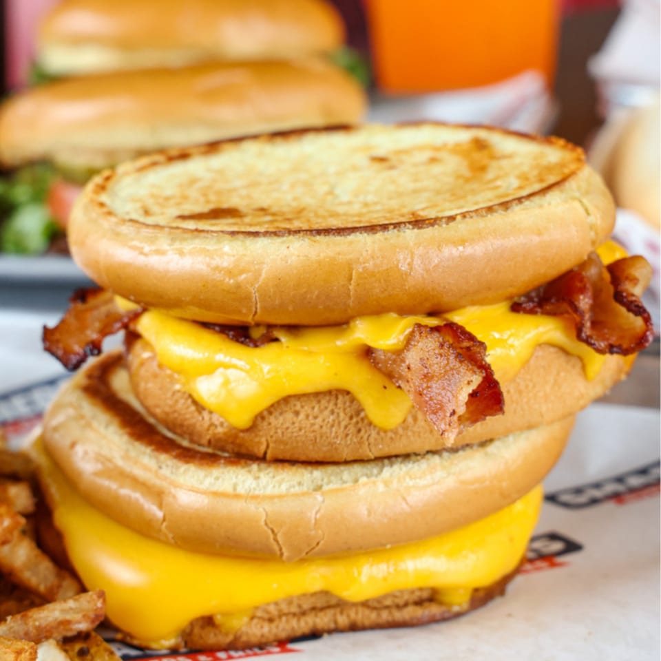 A double Smashers burger with melted cheese and crispy bacon, served with fries.